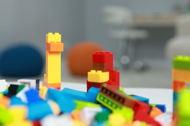 Photo of Construction toy. Figures made with building bricks and colorful blocks on table indoors, closeup