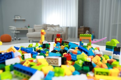 Photo of Construction toy. Figures made with building bricks and colorful blocks on table indoors