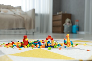 Photo of Construction toy. Figures made with building bricks and colorful blocks on floor indoors