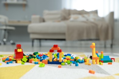 Photo of Construction toy. Figures made with building bricks and colorful blocks on floor indoors