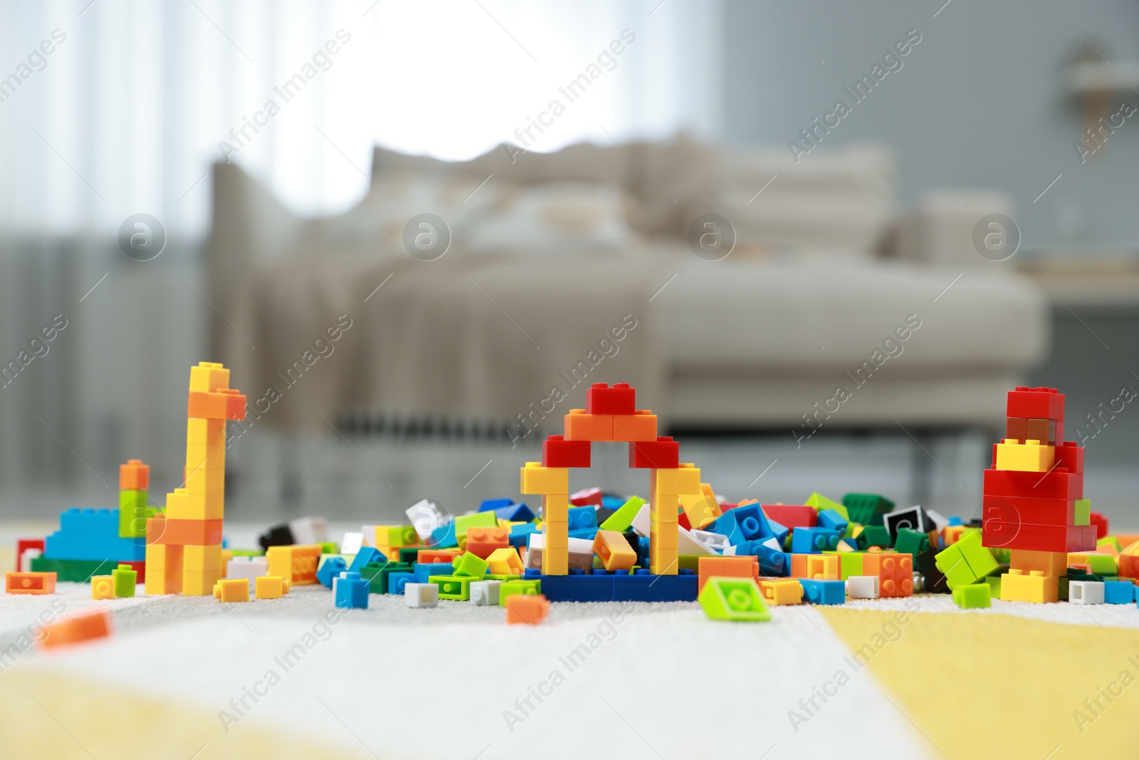 Photo of Construction toy. Figures made with building bricks and colorful blocks on floor indoors