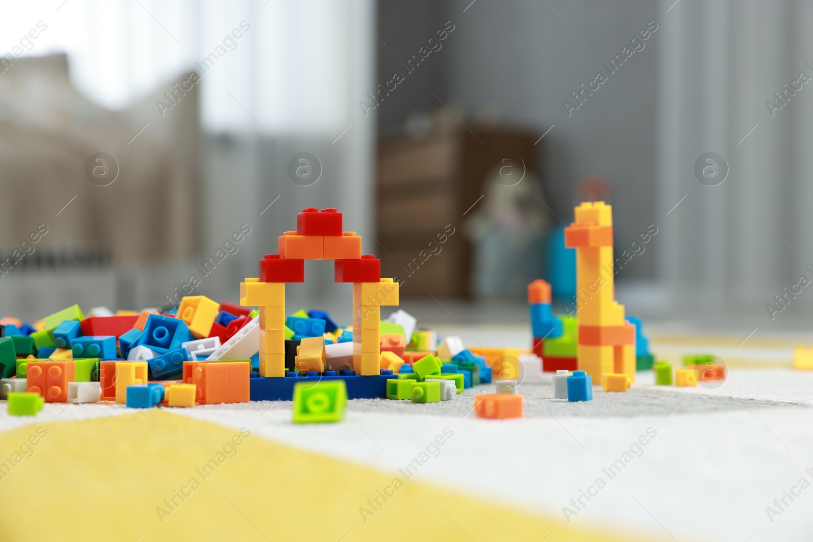 Photo of Construction toy. Figures made with building bricks and colorful blocks on floor indoors