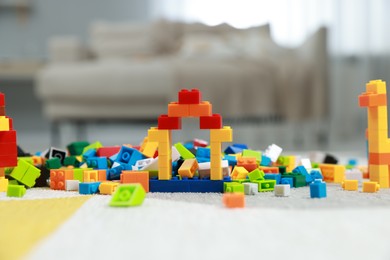 Photo of Construction toy. Figures made with building bricks and colorful blocks on floor indoors