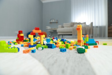 Photo of Construction toy. Figures made with building bricks and colorful blocks on floor indoors