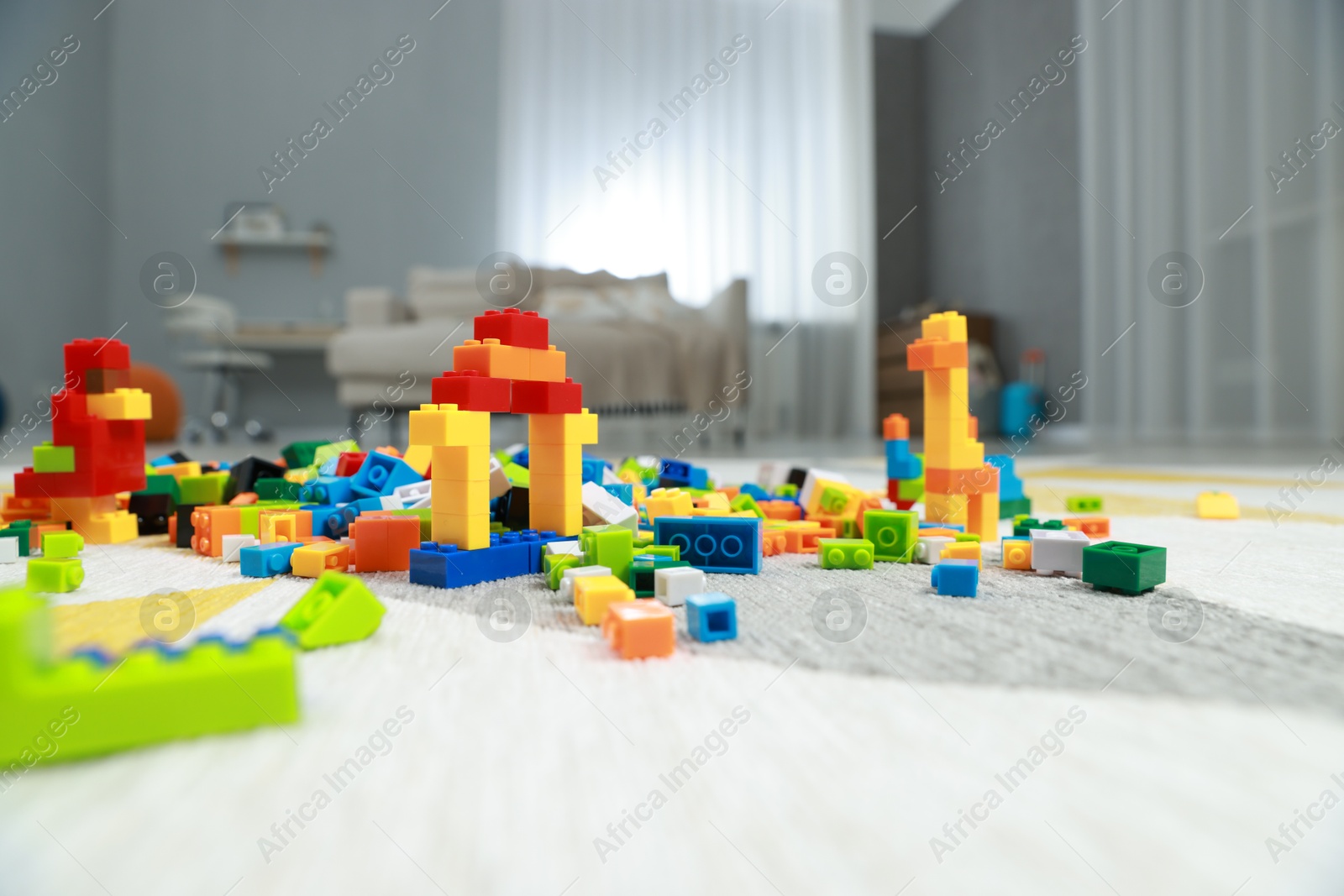 Photo of Construction toy. Figures made with building bricks and colorful blocks on floor indoors