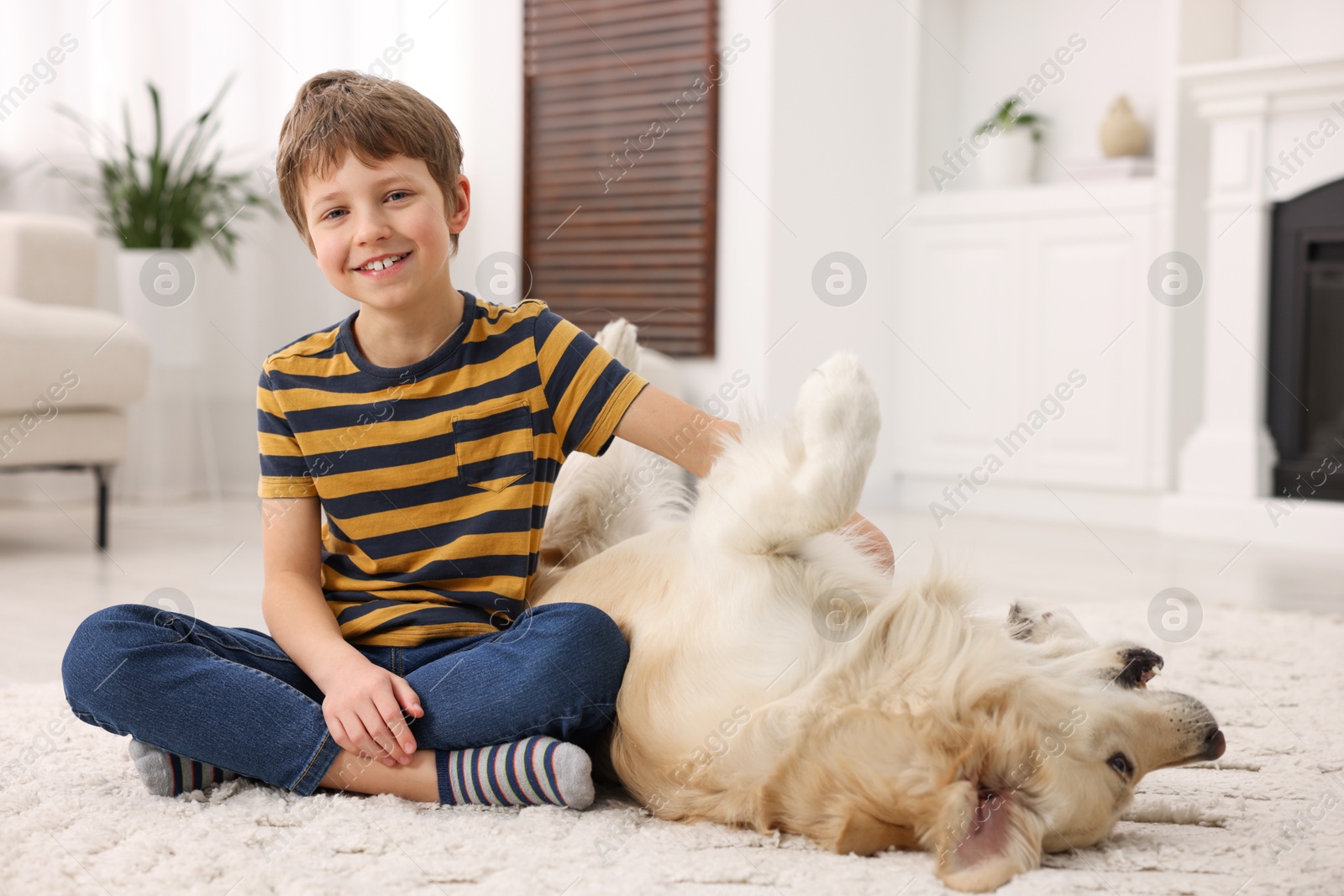 Photo of Boy playing with his cute dog at home