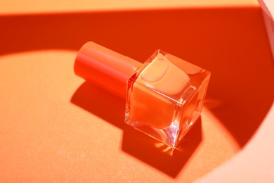 Photo of Nail polish in bottle on color background