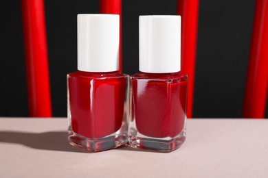 Photo of Red nail polishes in bottles on white table, closeup