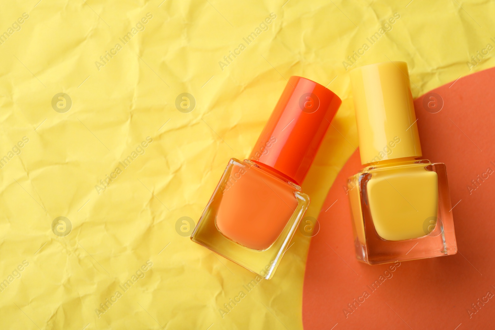 Photo of Nail polishes in bottles on color background, flat lay. Space for text