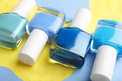 Photo of Set of nail polishes in bottles on color background, closeup