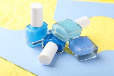 Photo of Set of nail polishes in bottles on color background, closeup