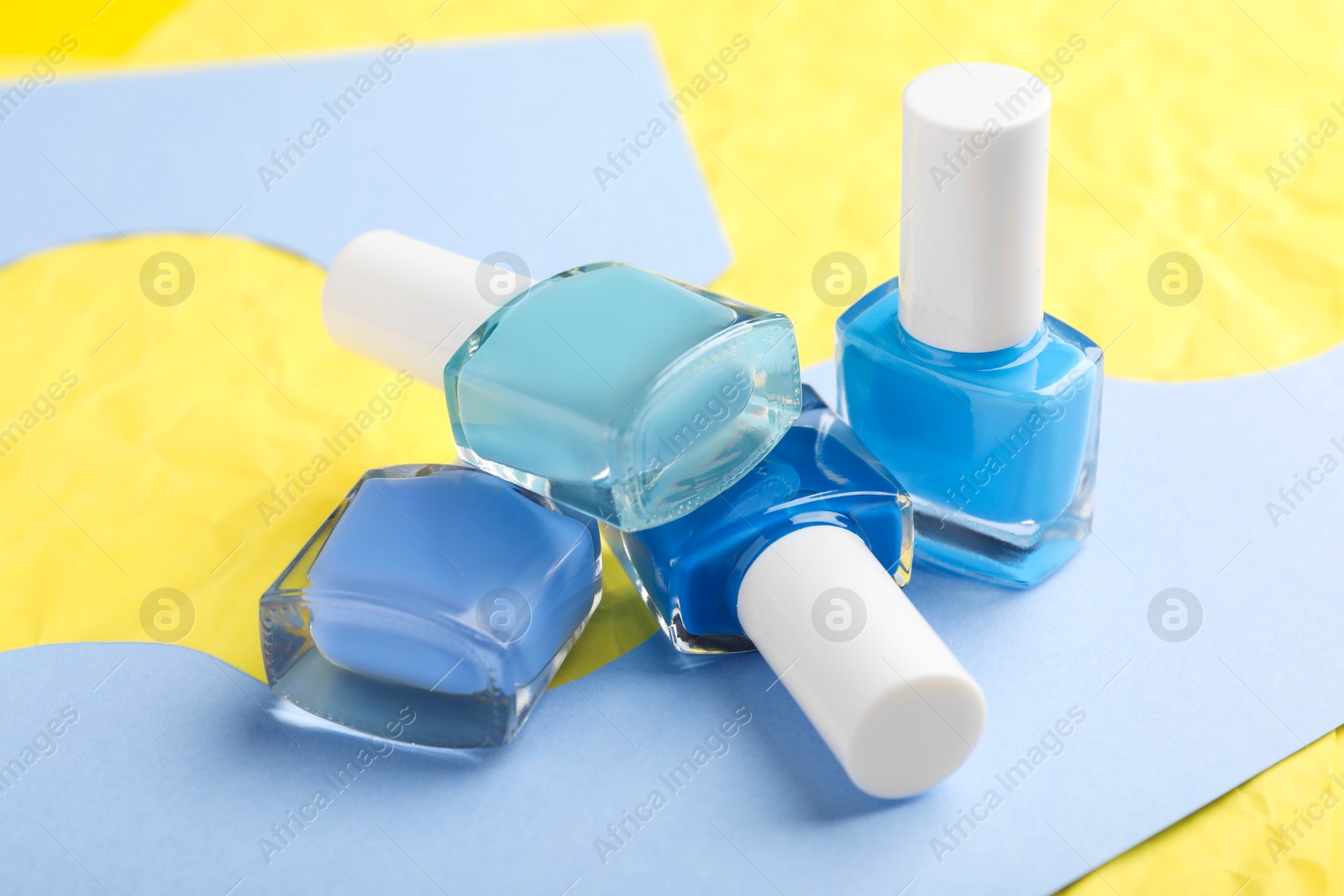 Photo of Set of nail polishes in bottles on color background, closeup