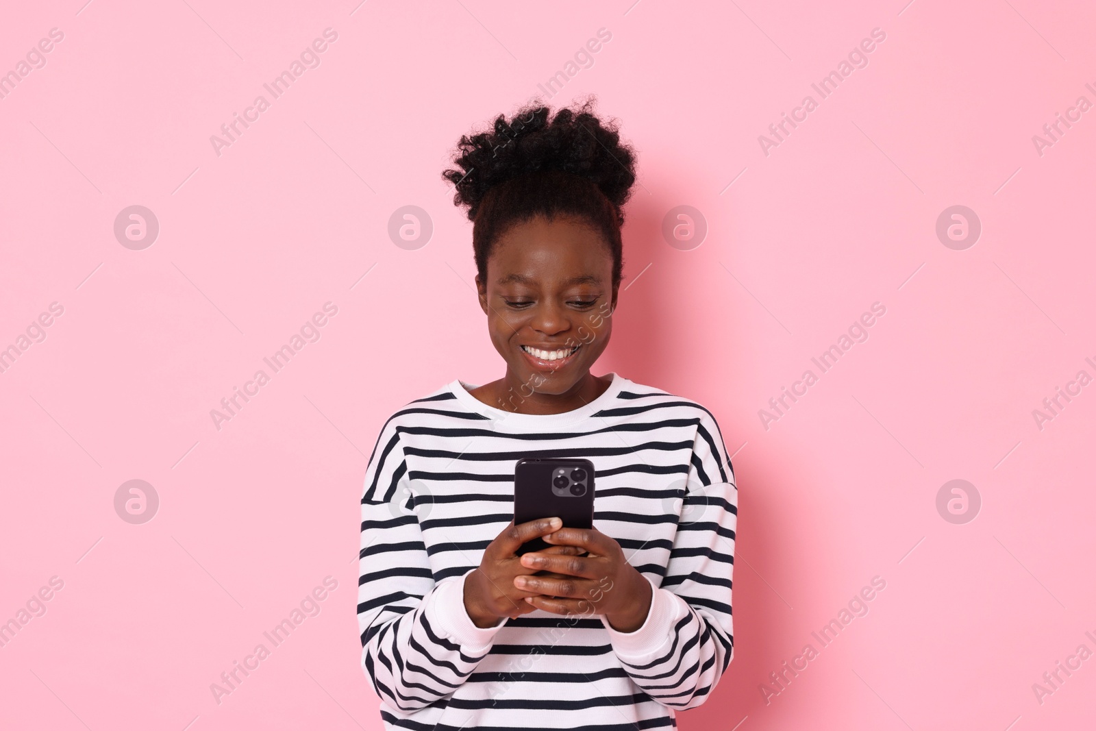 Photo of Happy woman with smartphone on pink background