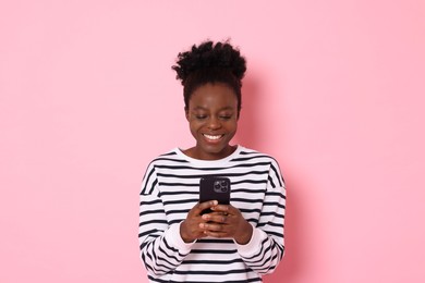 Photo of Happy woman with smartphone on pink background