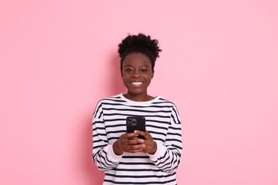 Photo of Happy woman with smartphone on pink background