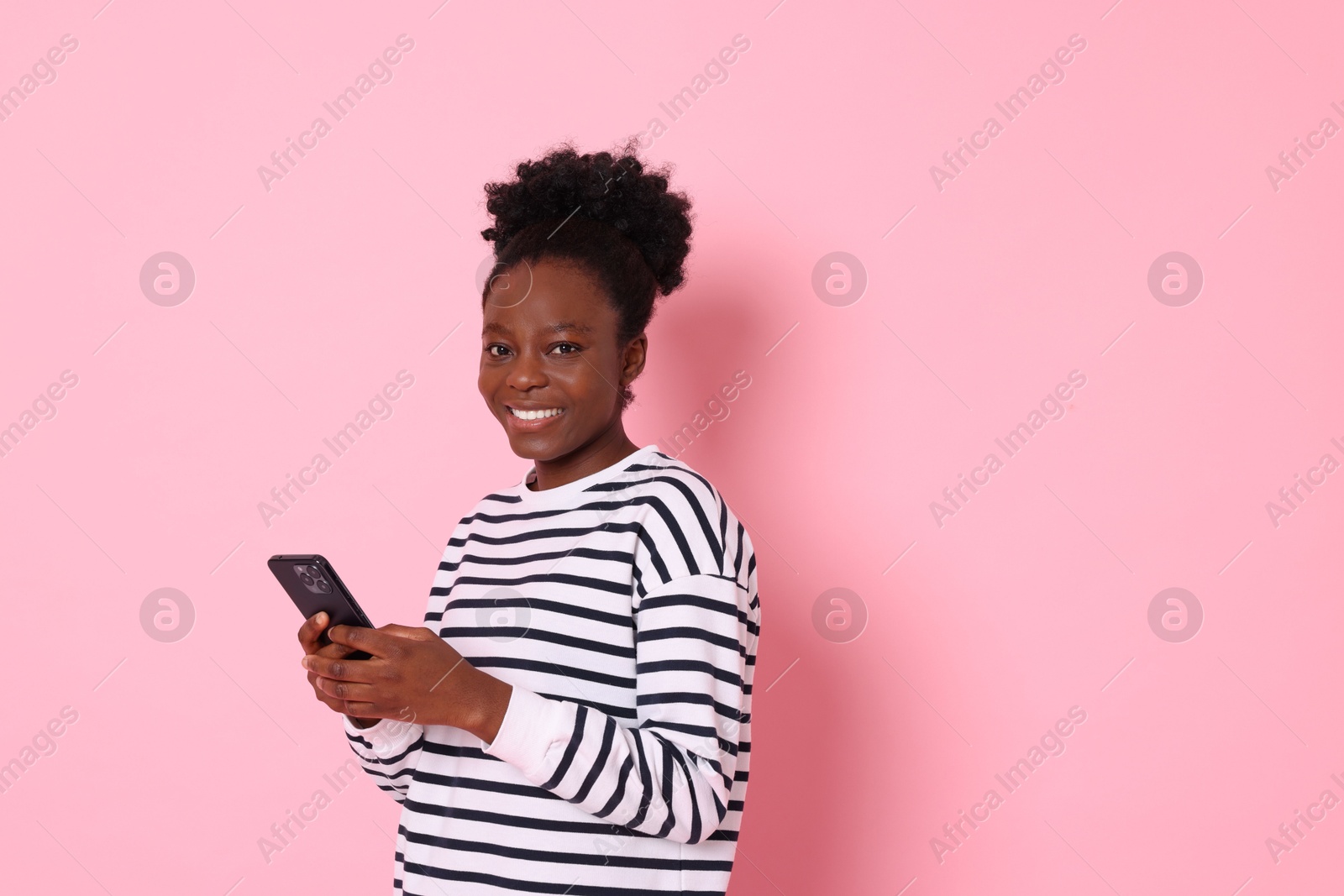 Photo of Happy woman with smartphone on pink background. Space for text