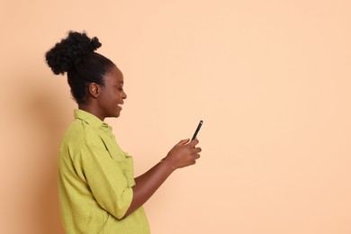 Photo of Happy woman with smartphone on beige background. Space for text