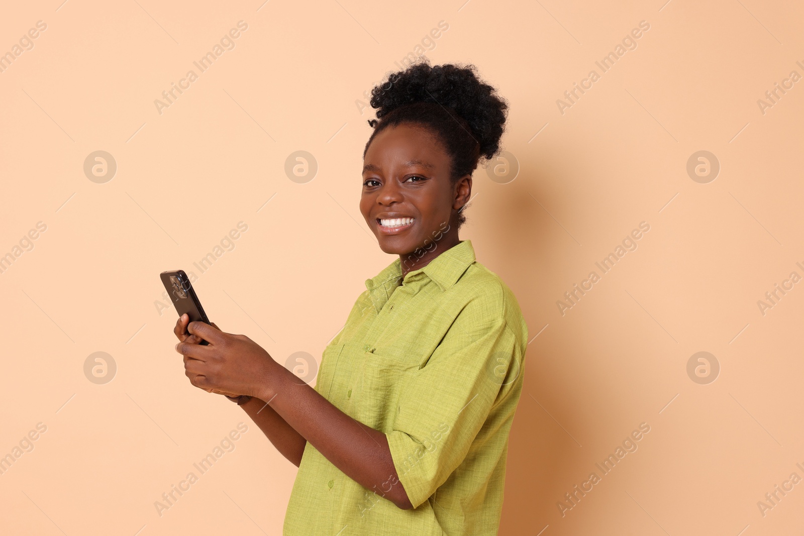 Photo of Happy woman with smartphone on beige background