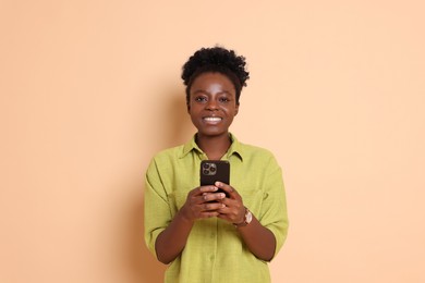 Photo of Happy woman with smartphone on beige background