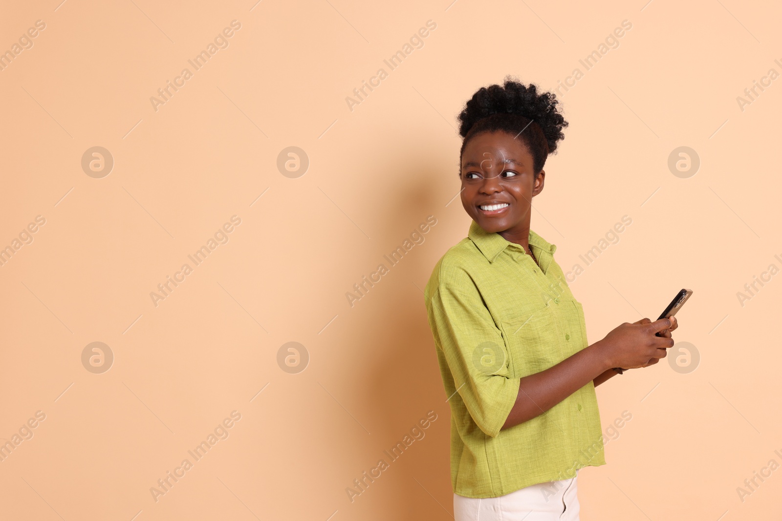 Photo of Happy woman with smartphone on beige background. Space for text