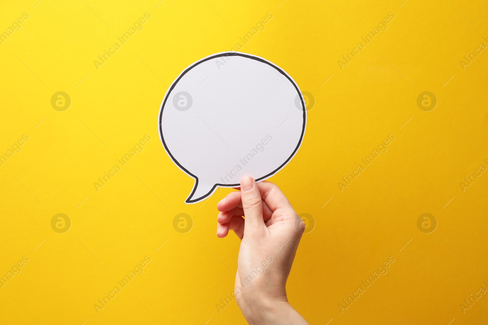 Photo of Woman holding blank speech bubble on yellow background, closeup. Space for text