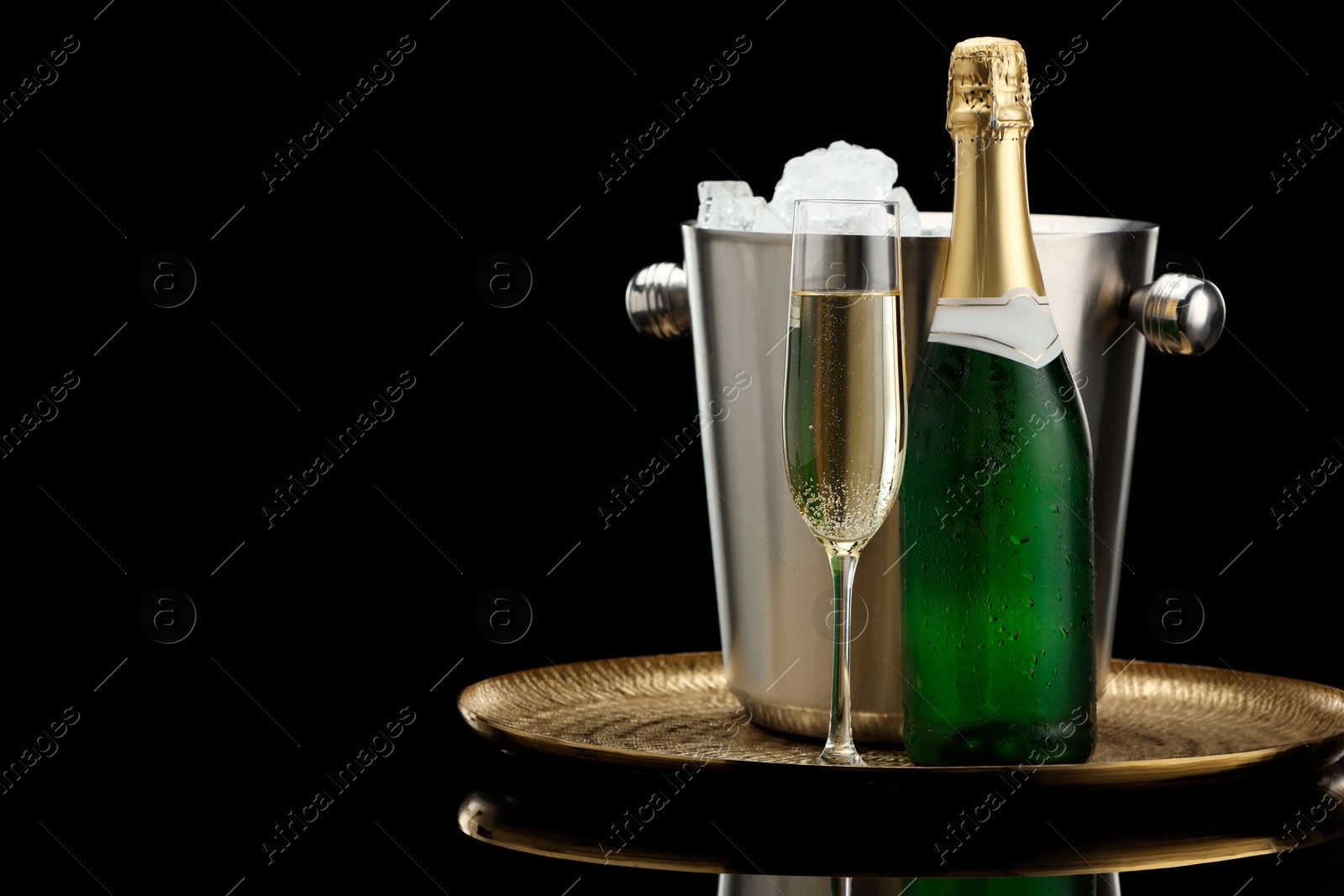 Photo of Sparkling wine and cooler bucket on black background. Space for text