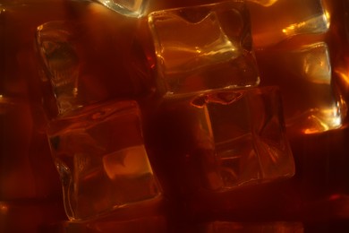 Photo of Refreshing coffee with ice cubes as background, closeup