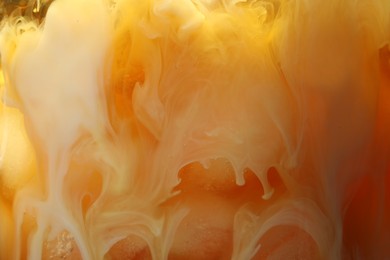 Photo of Refreshing coffee with ice and milk as background, closeup