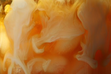 Photo of Refreshing coffee with ice and milk as background, closeup