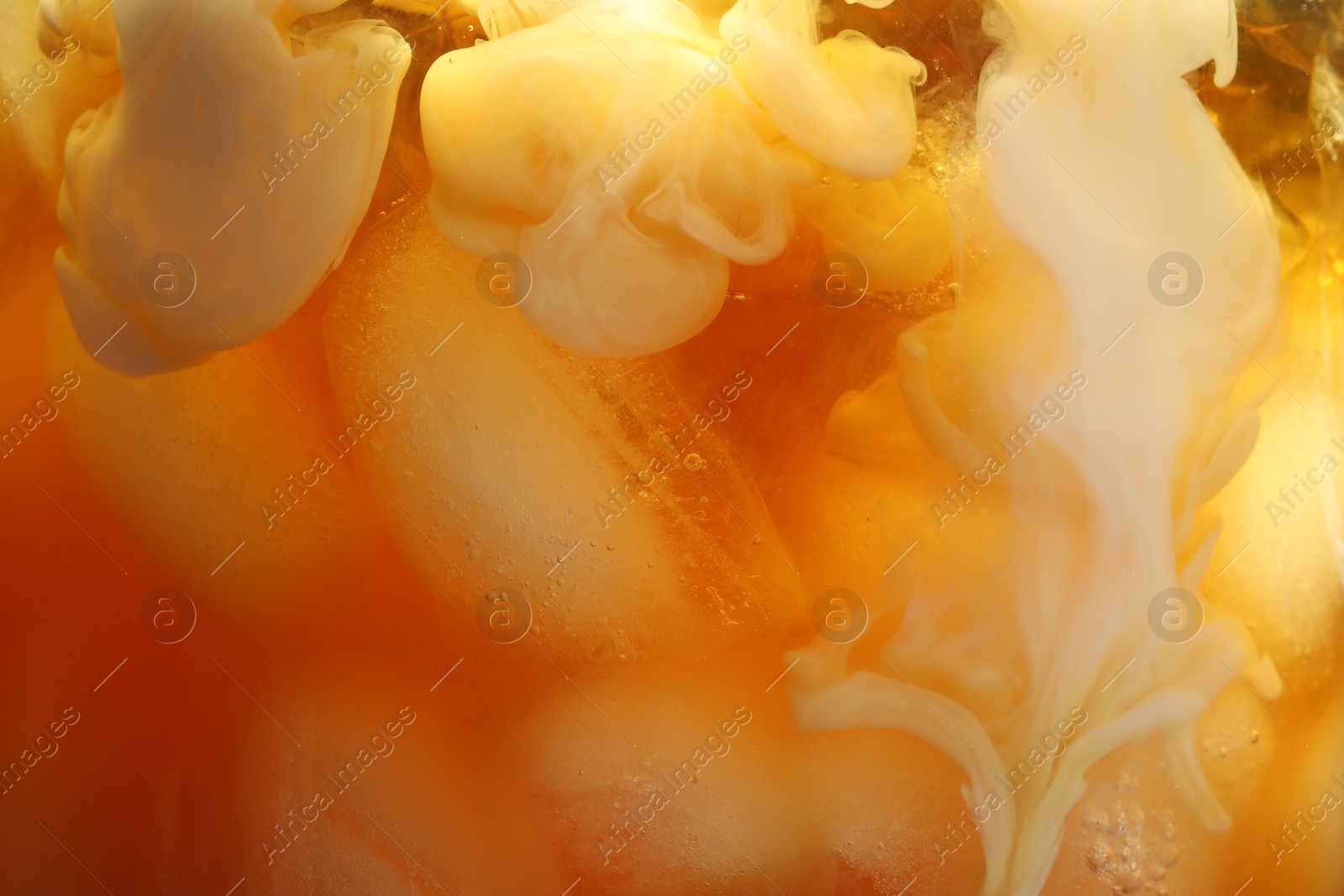 Photo of Refreshing coffee with ice and milk as background, closeup