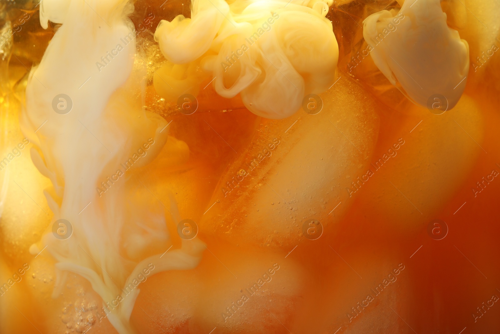 Photo of Refreshing coffee with ice and milk as background, closeup