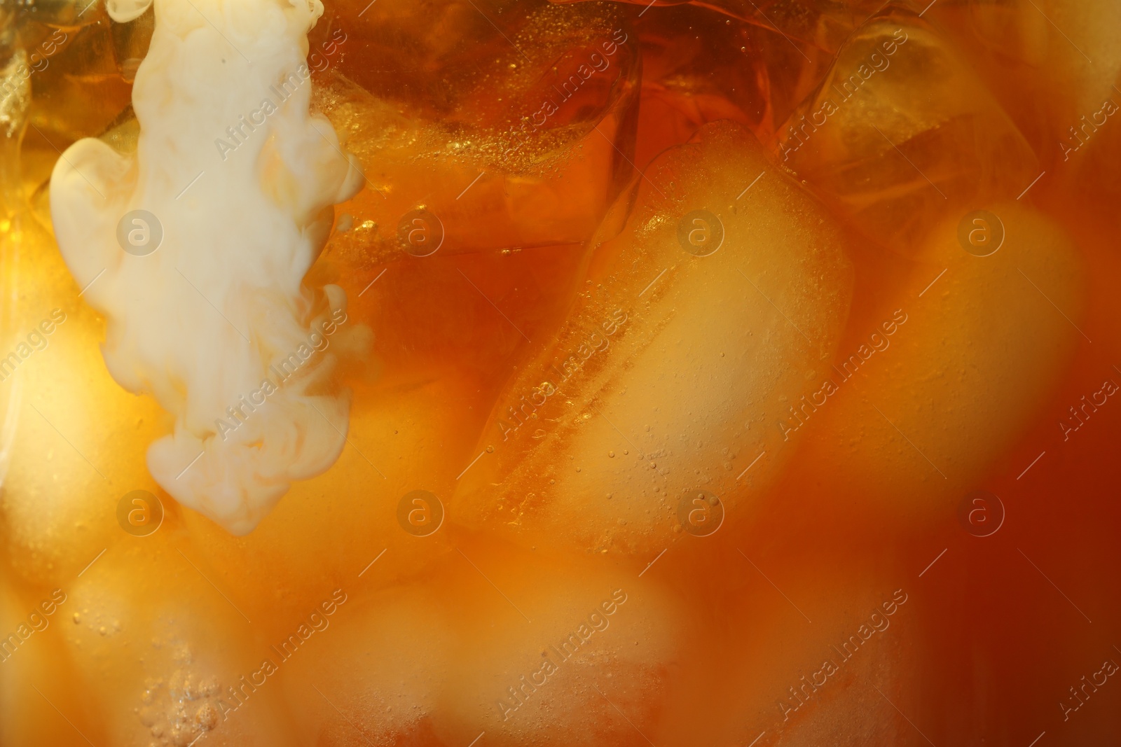 Photo of Refreshing coffee with ice and milk as background, closeup