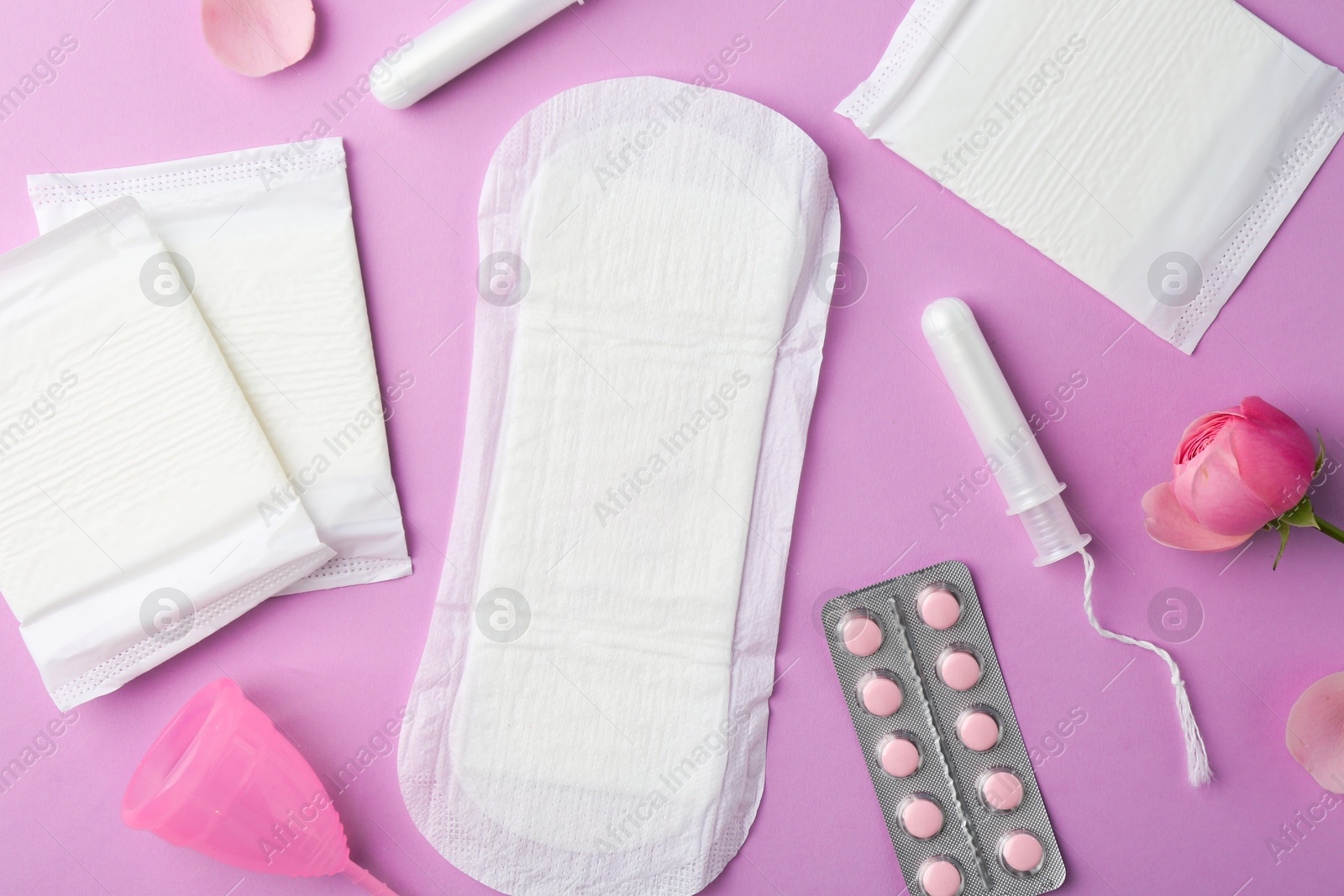 Photo of Flat lay composition with menstrual products on violet background