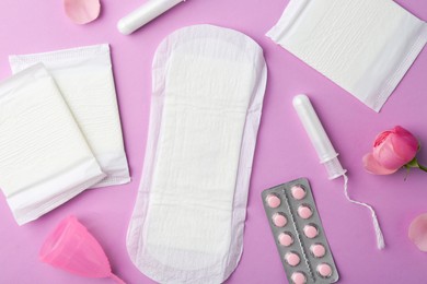 Photo of Flat lay composition with menstrual products on violet background