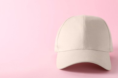 Photo of Stylish baseball cap on pink background, closeup. Mockup for design