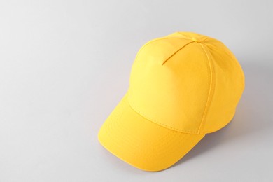 Photo of Stylish yellow baseball cap on light grey background. Mockup for design