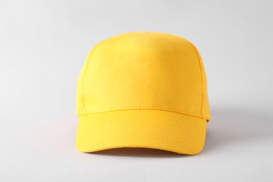 Photo of Stylish yellow baseball cap on light grey background. Mockup for design