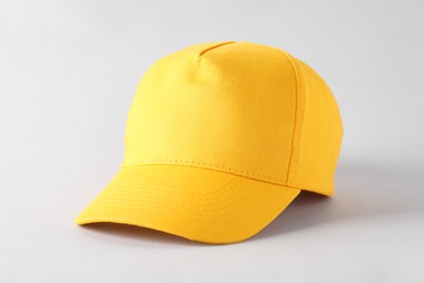 Photo of Stylish yellow baseball cap on light grey background. Mockup for design