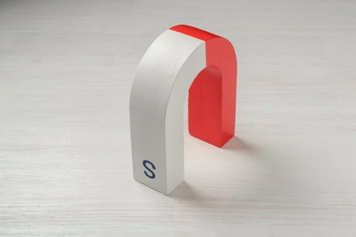 Photo of One horseshoe magnet on white wooden table