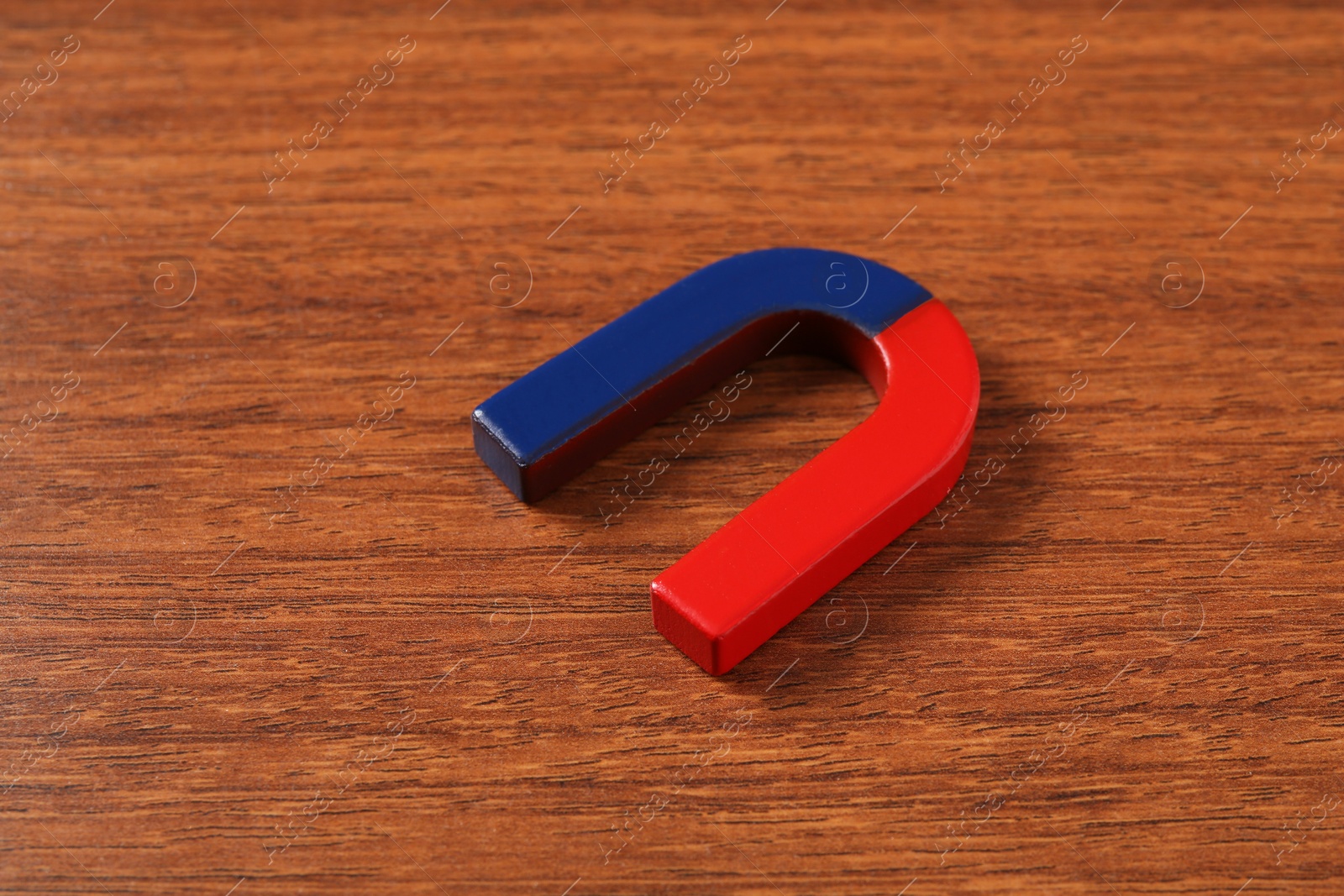 Photo of One color horseshoe magnet on wooden table