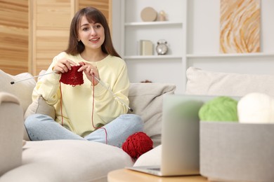 Photo of Beautiful woman learning to knit with online course at home