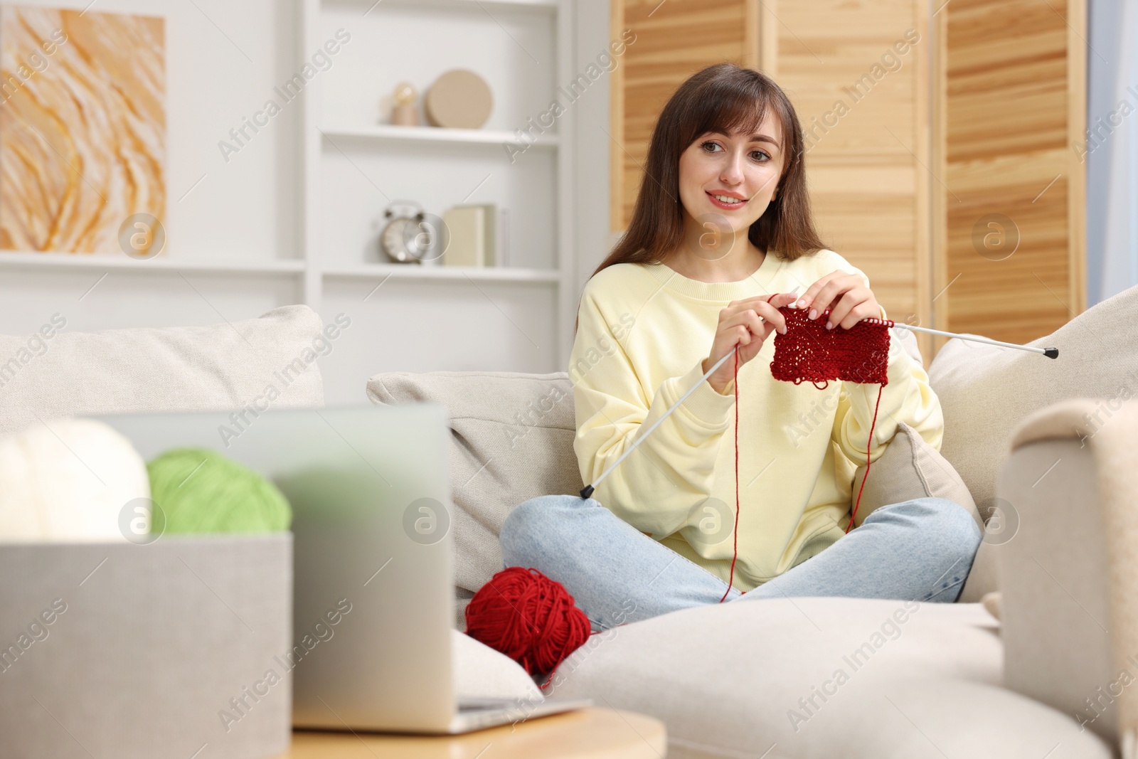 Photo of Beautiful woman learning to knit with online course at home