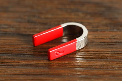 Photo of One horseshoe magnet on wooden table, closeup