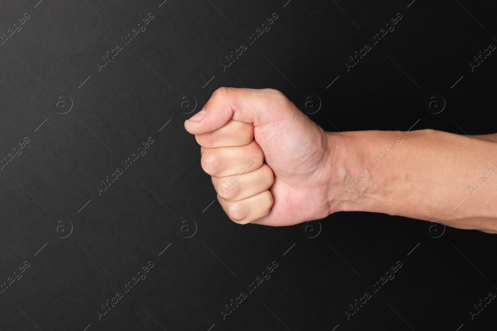 Photo of Man with bulging veins on his arm against black background, closeup. Space for text