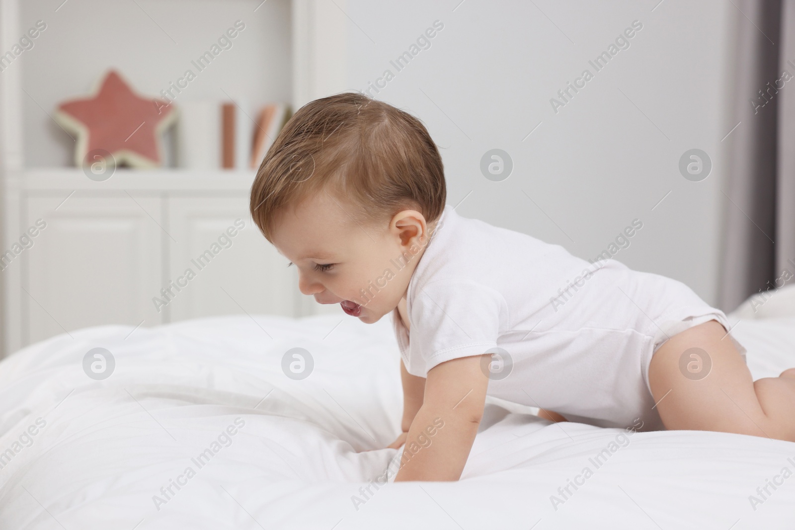 Photo of Funny little baby playing on bed at home