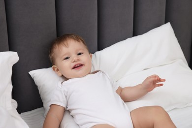 Photo of Funny little baby playing on bed at home