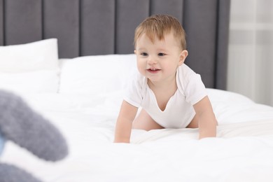 Photo of Cute little baby crawling on bed at home