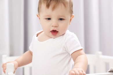 Photo of Cute little baby in crib at home