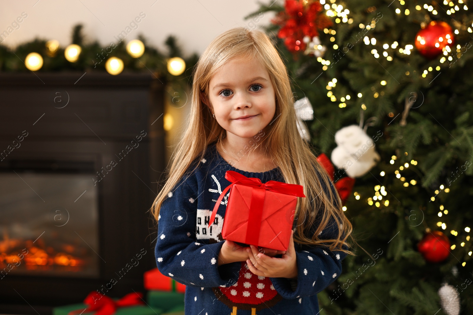 Photo of Little girl with Christmas gift at home