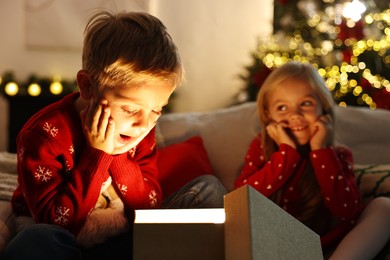 Photo of Little kids near open magic Christmas box at home